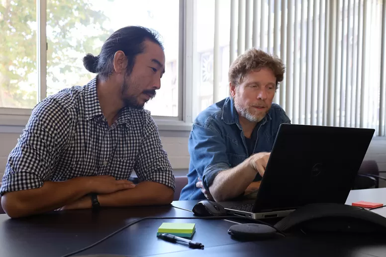 Two men looking at a laptop screen